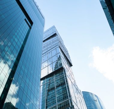 Detail blue glass modern office building background with cloud sky